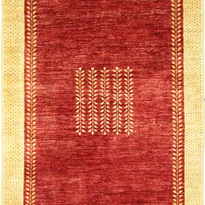 Puede incluir: Una alfombra roja con un borde amarillo y un patrón de hojas repetido en el centro.