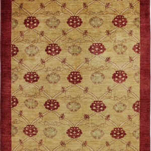 Puede incluir: Una alfombra beige con un borde rojo y un patrón repetitivo de flores y hojas estilizadas.