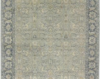 Könnte beinhalten: Ein grauer und beiger Teppich mit einem Blumenmuster. Der Teppich hat einen Rand mit einem sich wiederholenden Muster.