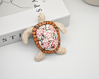 Handgemaakt schildpadstandbeeld: met bloemen versierde zeeschildpadsculptuur