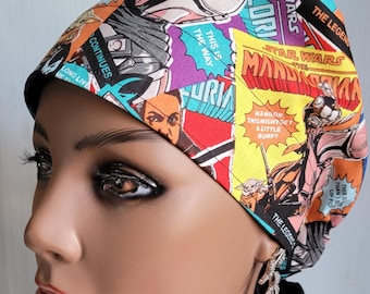 May include: A colorful Star Wars themed scrub cap featuring comic book style panels with characters and text. The cap has a black band and is designed to be worn on the head. The text includes "The Mandalorian", "This is the way", and "Star Wars".