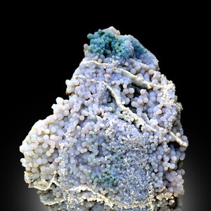 May include: A large, irregularly shaped agate geode with a variety of colors, including white, gray, blue, and green. The geode is covered in small, round nodules.