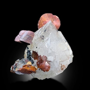 May include: A clear quartz crystal with multiple red-brown copper crystals attached to it. The quartz crystal is clear and has a sharp point. The copper crystals are shiny and have a metallic luster.