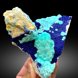 May include: A cluster of blue and green crystals on a rock. The blue crystals are a deep blue and the green crystals are a light green. The crystals are arranged in a random pattern.