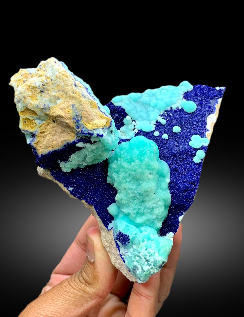 May include: A cluster of blue and green crystals on a rock. The blue crystals are a deep blue and the green crystals are a light green. The crystals are arranged in a random pattern.