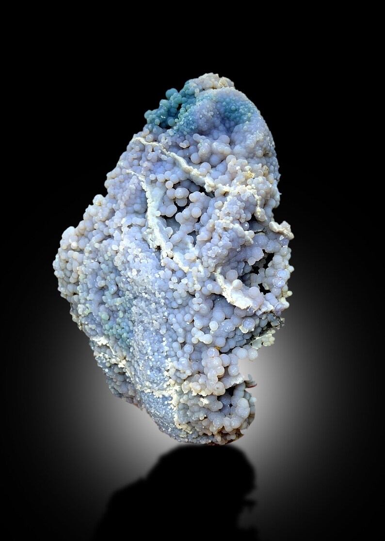 May include: A large, irregularly shaped, light blue and white agate with a bubbly texture. The agate has a smooth, polished surface and is a natural stone.
