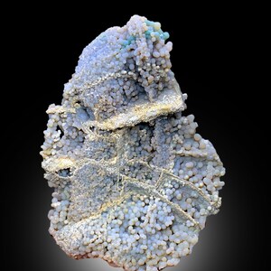 May include: A cluster of white, gray, and blue agate with a botryoidal texture. The agate has a rough, uneven surface and is covered in small, round nodules.