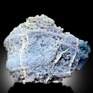 May include: A large, irregularly shaped, light purple and blue agate with a botryoidal texture. The agate has a smooth, polished surface and is covered in small, round nodules.