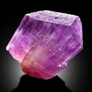 Puede incluir: Un gran cristal p&uacute;rpura transl&uacute;cido con estr&iacute;as. El cristal est&aacute; facetado y tiene un ligero tono rosado.