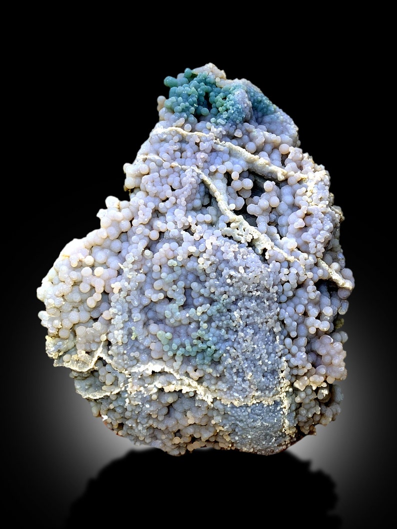 May include: A large, irregularly shaped agate geode with a variety of colors, including white, gray, blue, and green. The geode is covered in small, round nodules.