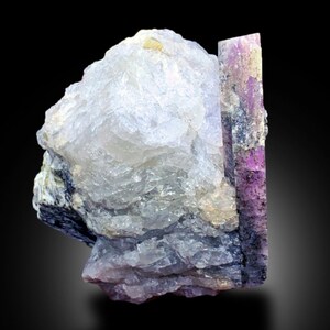 May include: A cluster of clear, translucent crystals with a large, purple and pink crystal attached. The crystals have a rough, natural texture.