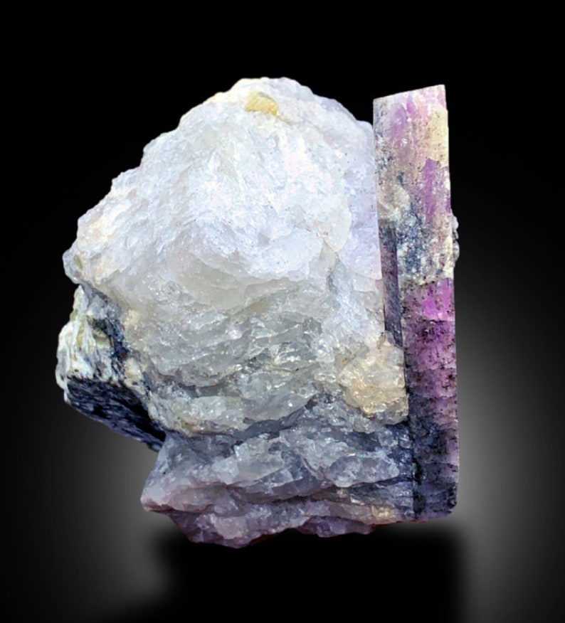 May include: A cluster of clear, translucent crystals with a large, purple and pink crystal attached. The crystals have a rough, natural texture.