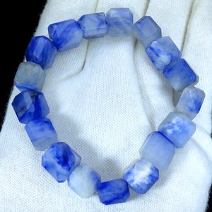 May include: A blue and white gemstone bracelet with a square shape. The bracelet is made of many individual stones that are strung together.