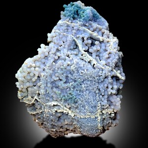 May include: A blue and white agate geode with a botryoidal texture. The geode is covered in small, round nodules that are clustered together. The geode is a natural formation and has a unique and beautiful appearance.