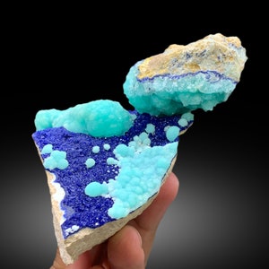 May include: A cluster of blue and turquoise mineral specimens on a rock. The mineral has a bubbly, textured surface.