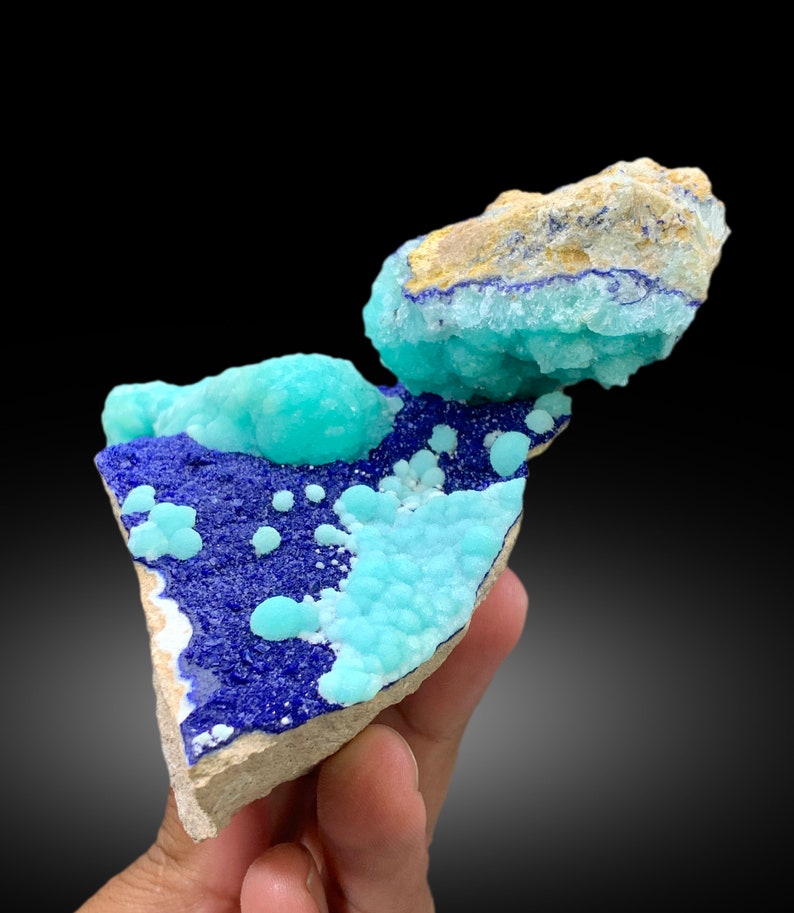 May include: A cluster of blue and turquoise mineral specimens on a rock. The mineral has a bubbly, textured surface.