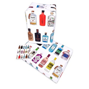 Pu&ograve; includere: Due rotoli di carta da regalo bianca con un motivo ripetuto di bottiglie di gin colorate. La carta &egrave; decorata con vari marchi di gin, tra cui Tanqueray, Bombay Sapphire e Hendricks.