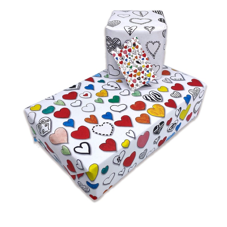 May include: A white gift wrap with a colorful heart pattern. The hearts are drawn in different styles and colors, including red, yellow, blue, green, and pink. The gift wrap is shown wrapped around a box with a matching gift tag.