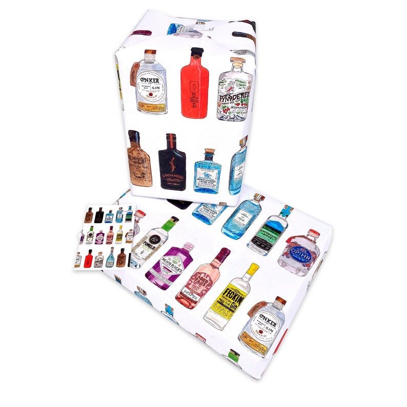 Pu&ograve; includere: Due rotoli di carta da regalo bianca con un motivo ripetuto di bottiglie di gin colorate. La carta &egrave; decorata con vari marchi di gin, tra cui Tanqueray, Bombay Sapphire e Hendricks.