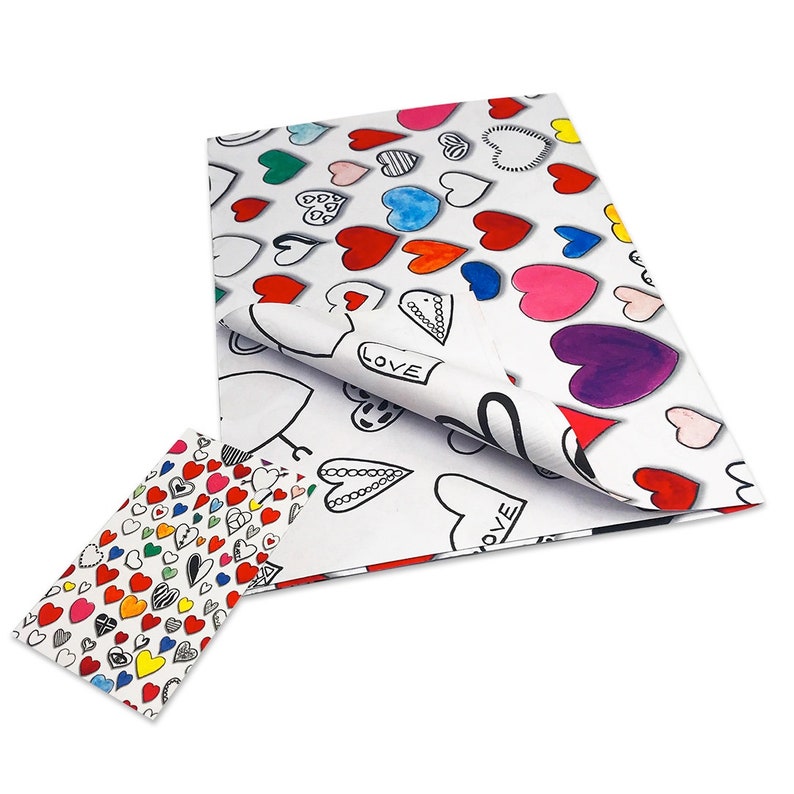 May include: White tissue paper with a colorful heart pattern. The hearts are in various colors, including red, pink, blue, green, and purple. The word "LOVE" is written on some of the hearts.