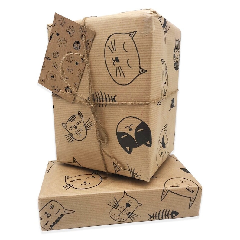 A 70cm x 50cm sheet of Mid Brown Ribbed Kraft paper wrap. Ink caricature Cute cat drawings over wrap, fish bones, mouse in hole & paw prints dotted around the cats. Mid weight paper, both strong and very easy to wrap with. Veg inks so 100% recyclable