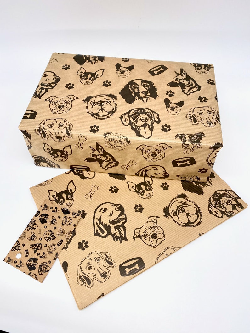 May include: Brown paper gift wrap with a repeating pattern of black dog silhouettes. The dogs are of various breeds and sizes, and the pattern also includes paw prints and bone shapes.