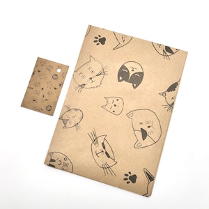 May include: Brown paper gift wrap with a repeating pattern of black and white cat faces. The paper is textured and has a subtle striped pattern.