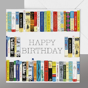 May include: A white card featuring a colourful illustration of a bookshelf filled with books. The text "HAPPY BIRTHDAY" is printed in black on the card.