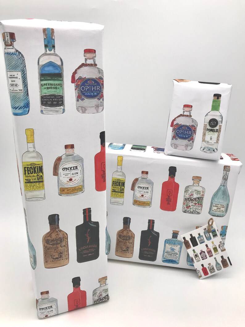 Pu&ograve; includere: Carta da regalo bianca con un motivo ripetuto di bottiglie di gin illustrate. Le bottiglie sono di vari colori e design, tra cui blu, verde, rosso e marrone. Il testo sulle bottiglie include "Feckin Gin", "Greensand Ridge", "OPIHR", "Bathtub Gin", "ONKER Gin", "Loch Mor", "PYNODEREE", "53 Pomelo", e "OPIHR".