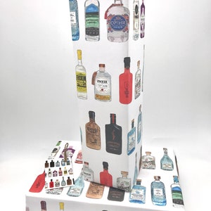 Pu&ograve; includere: Carta da regalo bianca con un motivo ripetitivo di bottiglie di gin illustrate. Le bottiglie sono di vari colori e stili, tra cui verde, rosso, blu e giallo. La carta &egrave; perfetta per avvolgere regali per gli amanti del gin.
