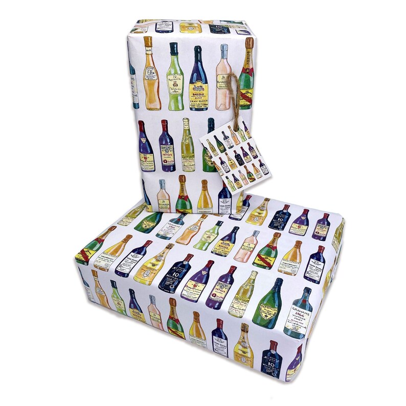 May include: Two white gift wrapping paper rolls with a colorful pattern of various bottles of wine and liquor. The paper is decorated with a repeating pattern of bottles of wine and liquor.