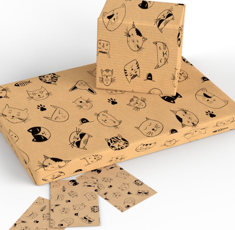 May include: Brown wrapping paper with a repeating pattern of black cat faces. The paper is rolled up and there are two smaller pieces of the same paper.