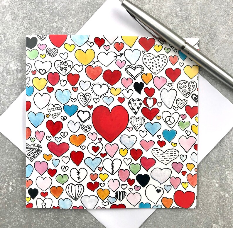 May include: A white card with a pattern of colorful hearts. The hearts are all different shapes and sizes, and some have designs on them. One large heart is red and filled in.