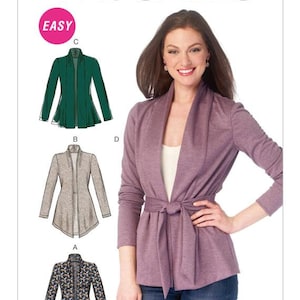 May include: McCall's sewing pattern featuring a woman wearing a purple wrap jacket. The pattern includes illustrations of different jacket styles, including a green, gray, and patterned jacket. The word "EASY" is in a pink circle.