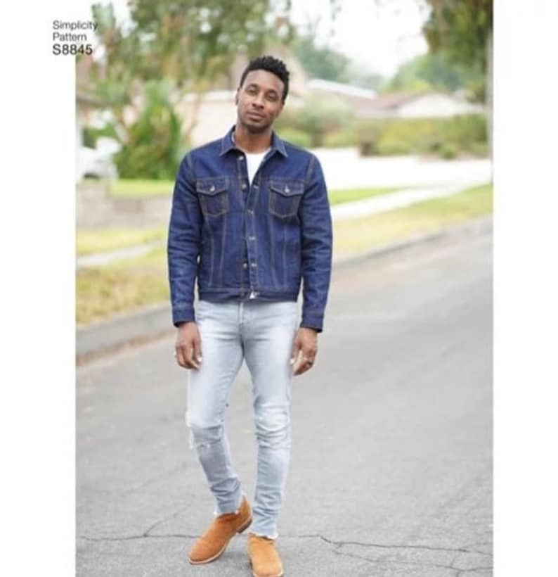May include: A person wearing a blue denim jacket, light blue jeans, and brown suede shoes.