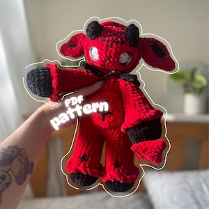 May include: A handmade red and black crochet doll with horns, large eyes, and a star-shaped belly. The doll has black accents on the ears, hands, and feet. The text "PDF pattern" is overlaid on the image.
