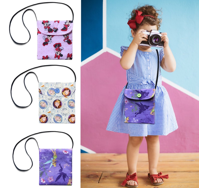 May include: Three different colorful crossbody bags with various cartoon characters. The bags have adjustable straps and a flap closure with a button. The bags are made of fabric and have a variety of designs, including Disney characters, Frozen characters, and fairies.