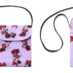 May include: A pink fabric crossbody bag with a black strap. The bag features a repeating pattern of Minnie Mouse in red and white. The bag has a flap with a button closure.