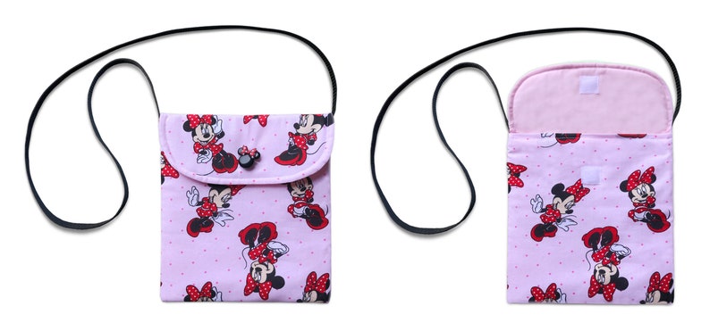 May include: A pink fabric crossbody bag with a black strap. The bag features a repeating pattern of Minnie Mouse in red and white. The bag has a flap with a button closure.