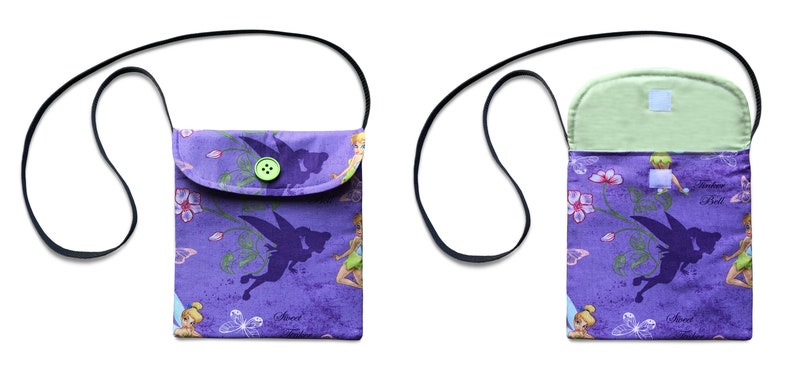 May include: Purple fabric purse with a flap closure and a green button. The purse has a black adjustable strap and features a print of fairies and flowers. The inside of the purse is lined with a light green fabric.