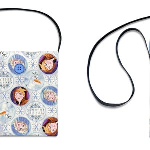 May include: A white fabric crossbody bag with a blue polka dot lining. The bag features a repeating pattern of Frozen characters, snowflakes, and the text "Let It Go".