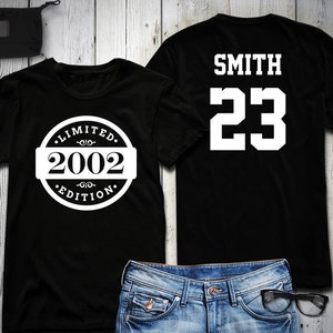 May include: Two black t-shirts. One shirt has a white circle with the text "LIMITED 2002 EDITION". The other shirt has the text "SMITH 23" in white.