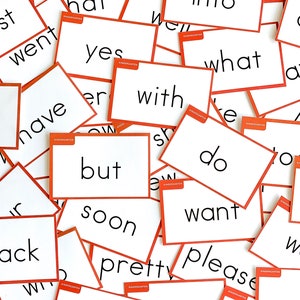 May include: A collection of white flash cards with orange borders and black text. The words on the cards include "what", "yes", "no", "into", "with", "but", "soon", "pretty", "please", "want", "do", "have", "went", "hat", "good", "are", "get", "all", "ack".
