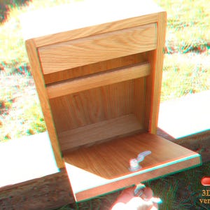 May include: A wooden box with a drawer and a shelf. The box is made of light wood and has a natural finish. The drawer is open and the shelf is empty.