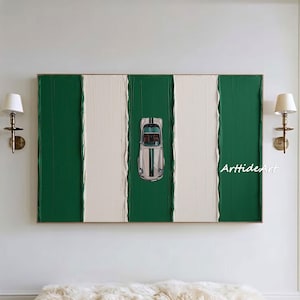 May include: Abstract wall art with a green and white striped design and a vintage car illustration. The artwork has a textured finish and is framed. The car is silver with black stripes. The artwork is displayed above a wooden bench with a white fur throw.