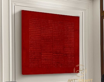 May include: A large, red abstract painting with a textured surface hangs on a white wall in a modern living room. The painting is framed in a white frame and is surrounded by white moulding.