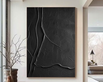 Può includere: Grande opera d'arte astratta nera strutturata in una cornice dorata. L'opera presenta un design a strati, tridimensionale, con forme curve e fluide. È esposta in una stanza moderna con pavimenti in legno e luce naturale.
