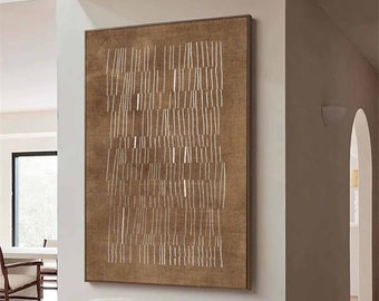 May include: A brown canvas wall art with a white abstract design. The art is hanging on a white wall in a modern living room with a white chair and a wooden stool.