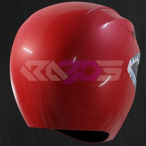 Op de afbeelding: Een glanzende rode helm met een gestileerd ontwerp, met een wit en grijs mondachtig detail aan de zijkant. De helm heeft de tekst "RAD3D5" in een roze en paarse gradi&euml;nt. Het ontwerp suggereert een superhelden- of cosplay-thema.