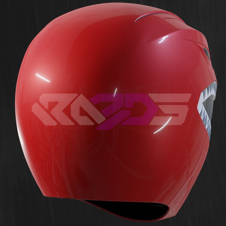 Op de afbeelding: Een glanzende rode helm met een gestileerd ontwerp, met een wit en grijs mondachtig detail aan de zijkant. De helm heeft de tekst "RAD3D5" in een roze en paarse gradi&euml;nt. Het ontwerp suggereert een superhelden- of cosplay-thema.